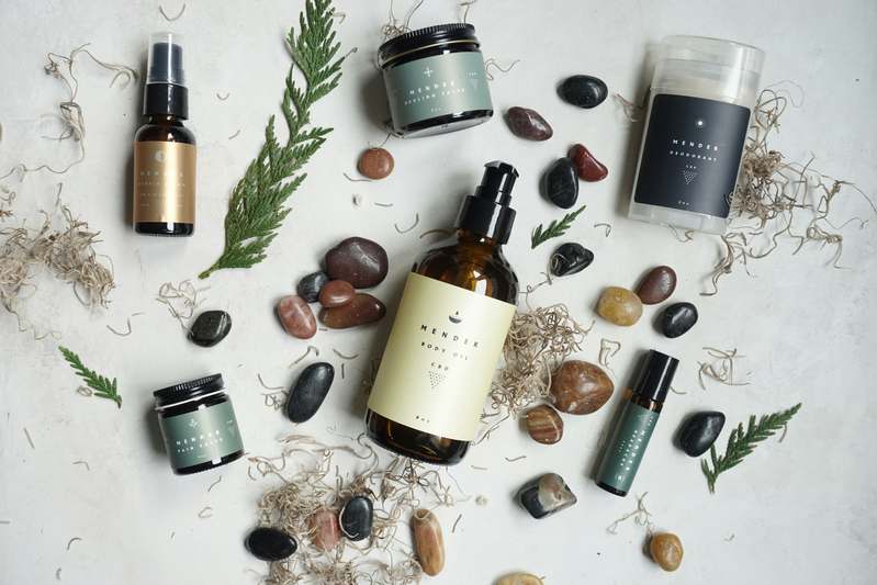 Woman holding natural makeup brushes next to organic skincare products